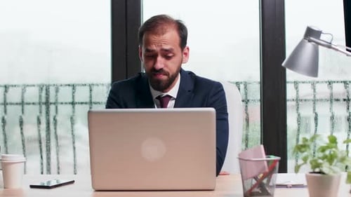 Man Talking into Laptop on Rainy Day