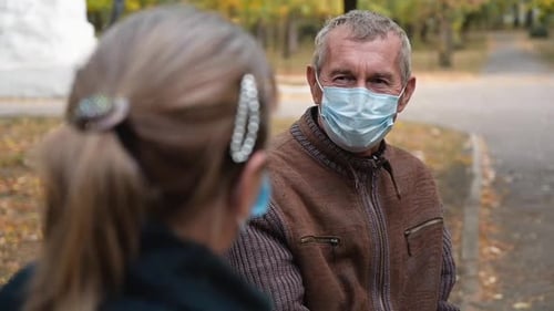 Senior Grandparents Couple in Medical Masks Sitting in Park