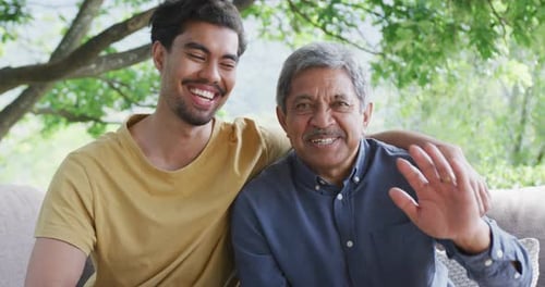 Smiling Father and Son Waving Outdoors
