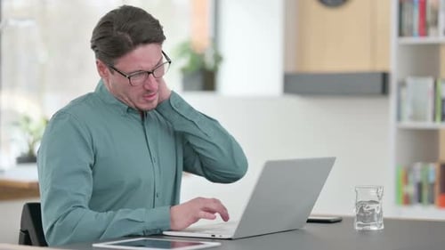 Adult Man Experiences Neck Pain While Typing on Laptop