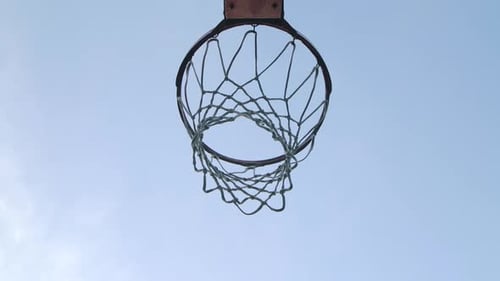 Basketballbälle fallen durch den Reifen in Richtung Kamera und treffen auf den Ring. Ansicht von unten. Nahaufnahme