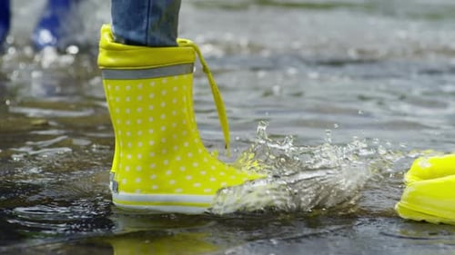 Child Splashing in Puddle with Polka Dot Rain Boots