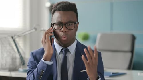 Man in Suit Arguing on Phone in Office