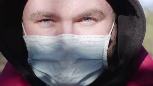 Extreme Close-up Face of Young Caucasian Man in Face Mask on Sunny Day Outdoors. Portrait of