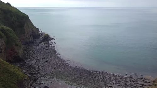 Drone tracking forward over a bay opening on the coast of Exmoor, Valley of Rocks. Amazing turquoise