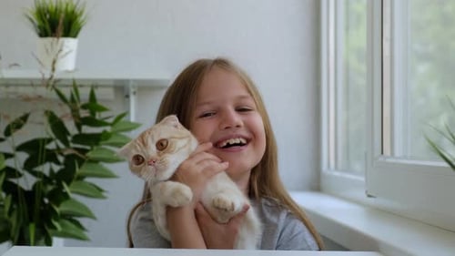 Smiling Girl with Fluffy Cat Indoors