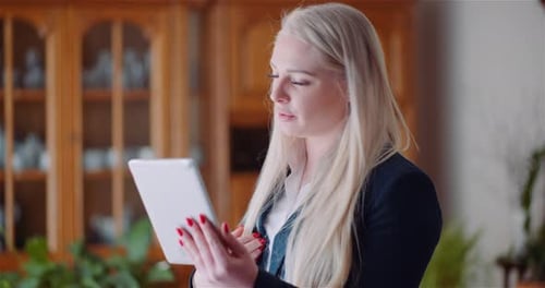 Woman Using Tablet and Talking in Home Setting