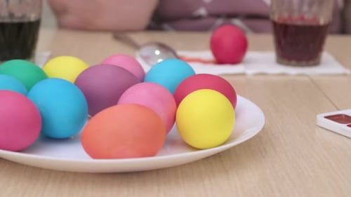 Happy Family Painting Colorful Eggs with Water Food Colors for Easter