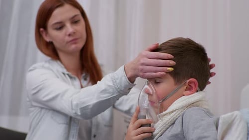 Mother Comforts Sick Child Using Nebulizer Mask
