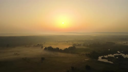 Aerial Landscape View of Sunny Morning Over Foggy Green Fields