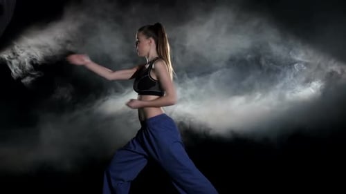 Woman Practicing Martial Arts in Smoky Studio
