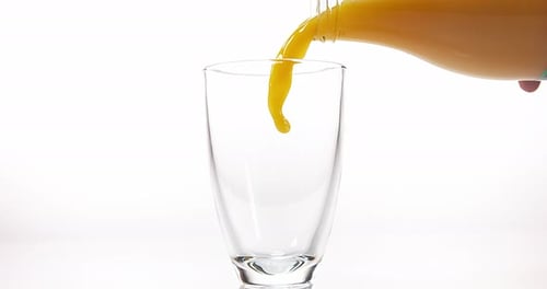 Orange Juice Poured into a Glass on White