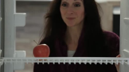 Woman Takes an Apple from the Refrigerator