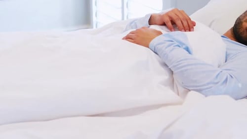 Man sleeping on bed in bedroom