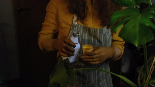 Woman Prepares Liquid for Indoor Plant