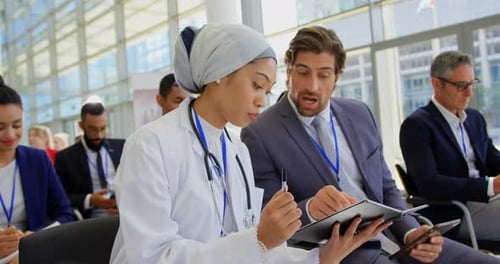 Female doctor discussing over digital tablet in the business seminar 4k