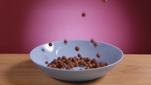 Cereal Balls Being Poured Into Blue Bowl