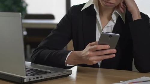 Female Office Worker Chatting in Smartphone Sitting Front of Laptop, Technology