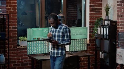Male Broker Analyzing Stock Market Statistics on Digital Tablet