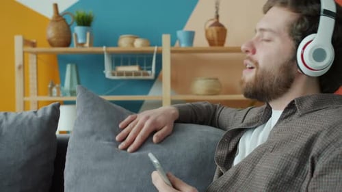 Man Listening to Music with Headphones on Couch