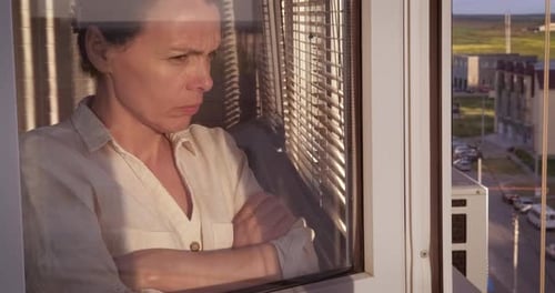 Woman Looking Out Window with Pensive Expression