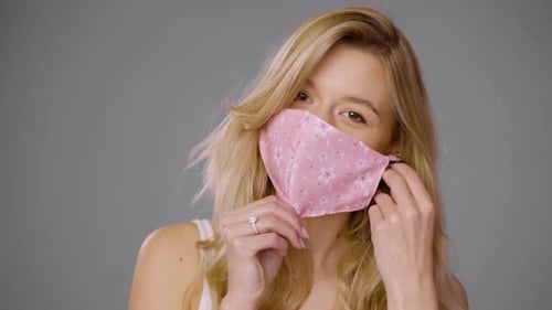 Woman Adjusting Mask and Looking at Camera