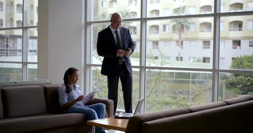 Businessman and His Assistant Woman Is Talking in Hall of Business Center, Man Is Walking