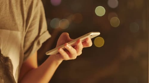 Woman's Hand Holding Phone at Night