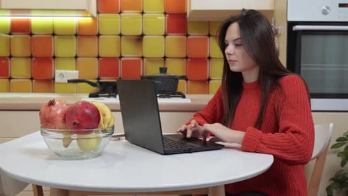 Linda jovem trabalhando em casa usando um laptop