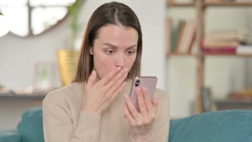 Young Woman Reacts to Content on Mobile Phone
