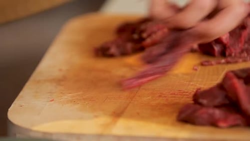 Hands Cutting Raw Meat With Sharp Knife