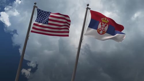 United States and Serbia National Flags Waving Against Clouds