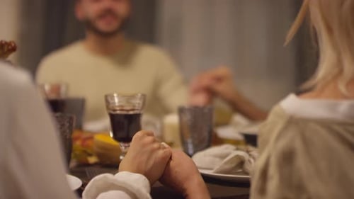 Friends and Family Holding Hands at Dinner