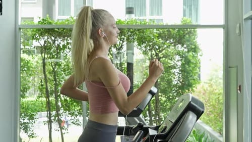 Woman Running on Treadmill at Gym