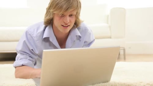 Young Adult Relaxing at Home with Laptop