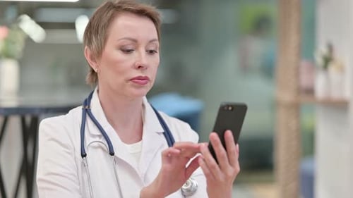 Adult Woman Doctor Using Cell Phone in Hospital