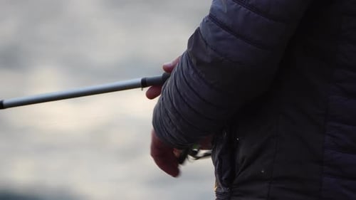 Mann, Hobby, Angeln auf See, zieht eine Angelschnur fest, eine Angelrolle, im Sommer