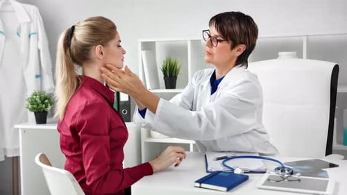 Professional Female Doctor Checking Patient Neck Examining Glands at Modern Clinic White Interior