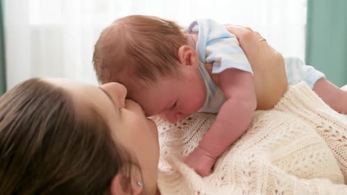 Loving Mother Holding Newborn Infant Close