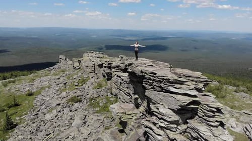 Woman on Top of a Mountain on the Rocks, Raises His Hands Up and Rejoices, The Concept of Freedom