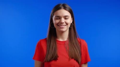 Woman Smiling in Red Shirt on Blue Background