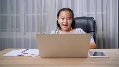Smiling Child Studying With Laptop at Home