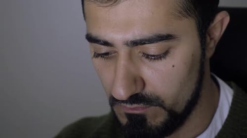 Man looks at laptop screen and works