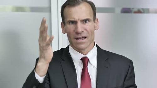 Angry Businessman Gesturing in Office Setting