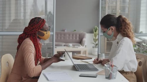 Coworkers Meeting At Table With Masks And Laptop