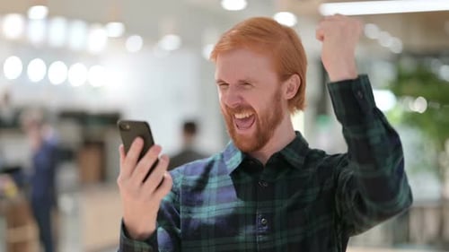 Man Smiles at Good News on His Phone