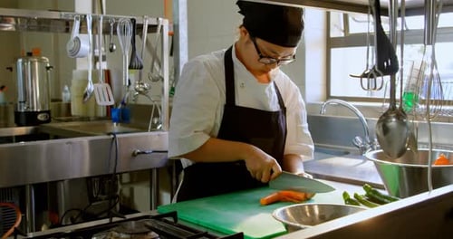 Chef Carefully Cuts Vegetables in Bright Kitchen