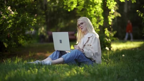 Woman Working on Laptop in Park Setting