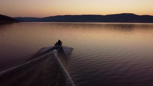 Aerial View of a Fishermens on a Speed Motor Boat Fishing on a Lake with Beautiful Sunrise