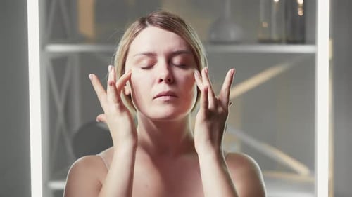 Woman Massaging Face in Close Up Beauty Shot